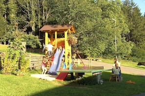 Ein Spielplatz mit Rutschen und einem kleinen Pavillon.