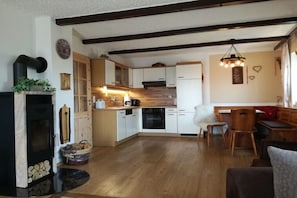 Eine gemütliche Küche mit Holzschränken, einem eingebauten Backofen und einem Kamin.