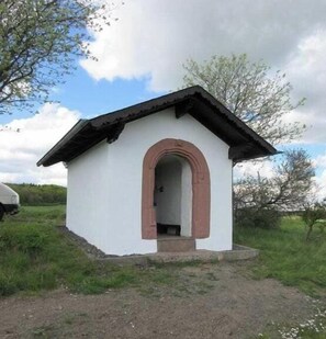 Ein kleines, einstöckiges Gebäude mit Satteldach und rundbogigem Eingang.