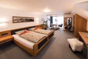 Ein Schlafzimmer mit einem Bett, Nachttischen, einem Schreibtisch und einem Stuhl.