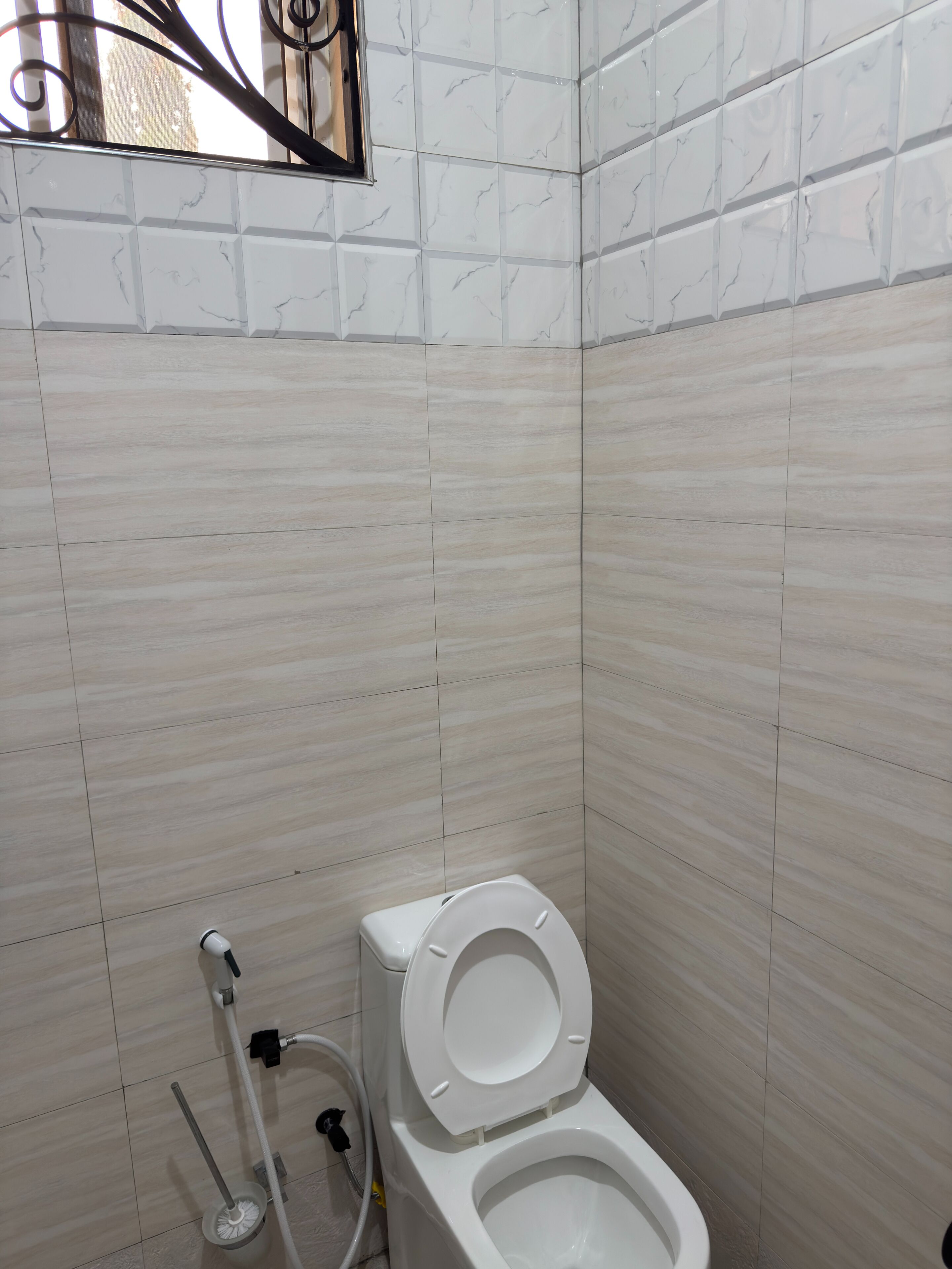 Ein Badezimmer mit Toilette, Handtrockner und Stand-Bidet.
