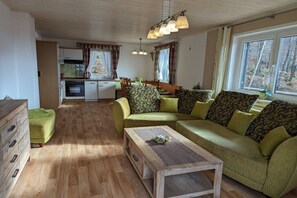 Ein gemütliches Wohnzimmer mit einer Couch, einem Couchtisch und einem Essbereich mit Tisch und Stühlen.