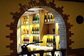 A wine cellar with shelves of wine bottles and a wine glass on a table. - at the Steffen-Prüm winery (Maring-Noviand)