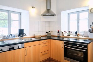 Eine moderne Küche mit Geschirrspüler, Backofen und einem großen Fenster.