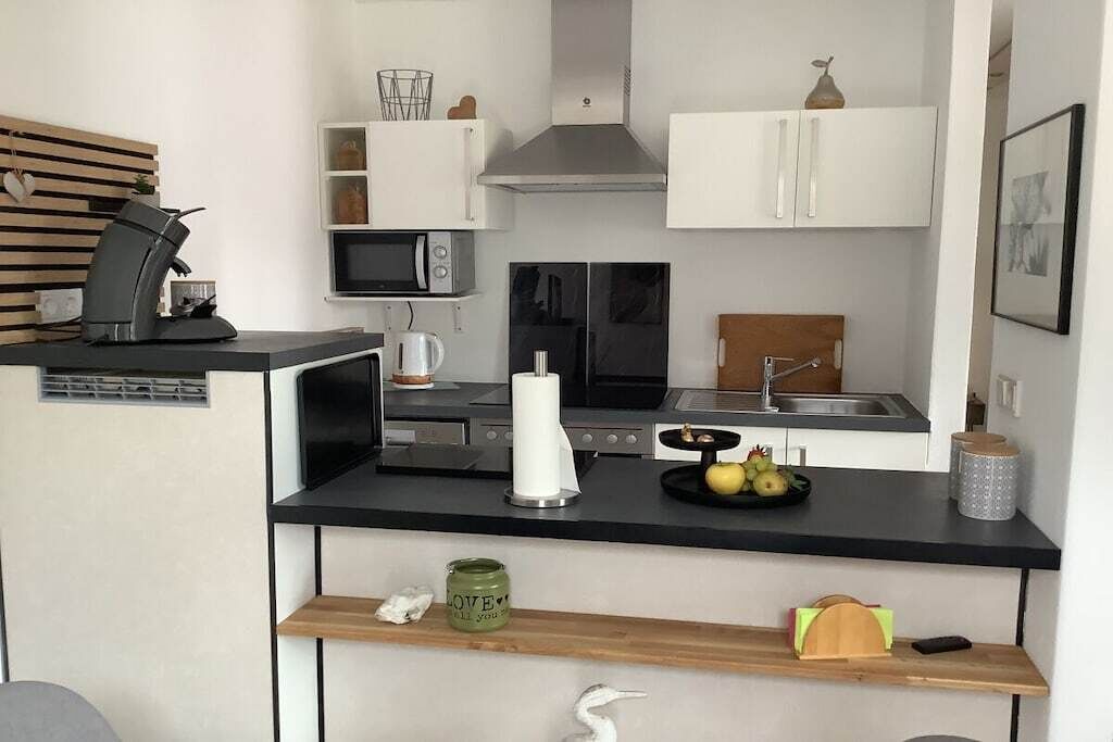 Eine kleine Küche mit Kaffeemaschine, Mikrowelle und einem Kühlschrank.