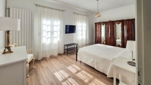 A bedroom with a bed, a desk, a chair, a TV, and a wardrobe. - Casa degli Orti in Venice (Dolo)