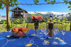 Ein Tisch mit einem Apfelkorb, einer Blumenvase und Weingläsern.