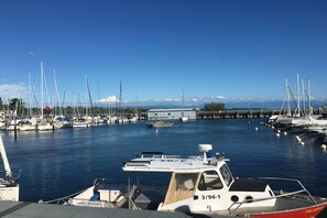 Ein Hafen mit vertäuten Booten, ein klarer Himmel und eine entfernte Bergkette.