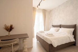 Ein Schlafzimmer mit Bett, Schreibtisch und Stuhl.