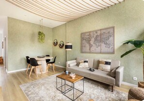 Ein modernes Wohnzimmer mit Sofa, Couchtisch und Essbereich.