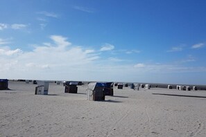 Ein sandiger Strand mit mehreren kleinen, beweglichen Bauwerken.