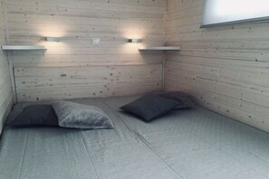 Ein Zimmer mit Holzwänden, zwei Kissen und zwei Wandleuchten.