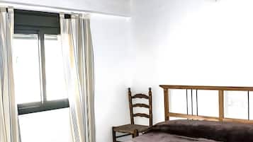 Tabla de planchar con plancha y ropa de cama