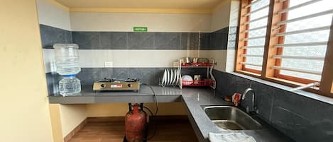 A kitchen with a gas stove, sink, and a water dispenser.