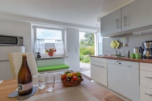 A modern kitchen with a dining area, a view to the outside, and a window with a view. - Holiday apartment with 1 bedroom (Königstein im Taunus)