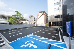 A parking lot with designated handicapped spaces, marked arrows, and a blue handicapped parking sign. - Pohang City Hotel (Pohang)