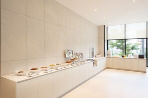 A modern kitchen with a long counter displaying various food items and appliances. - Pohang City Hotel (Pohang)