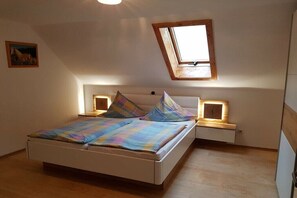 A bedroom with a bed, a skylight, bedside lamps, and a small painting on the wall. - Holiday home in Miltach with swimming pool (Miltach)