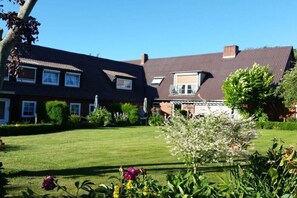 A residential building with a well-maintained lawn and garden. - Holiday apartment with 2 bedrooms (Steinberg)