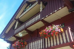 Ein mehrstöckiges Gebäude mit Balkonen, schmiedeeisernen Geländern und Blumenkästen.