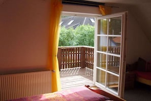 A bedroom with a window, a radiator, and a bed. - Holiday apartment with 1 bedroom (Prerow\/Ostseebad)