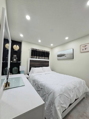 A bedroom with a bed, bedside table, mirror, and a painting on the wall. - Ligero Townhouse Entire Four Bedrooms Home (Orangeville)