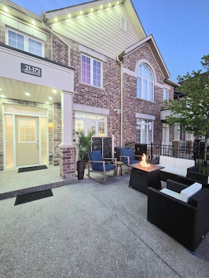 A brick building with a sign '21-17 PARKINSON CR' and outdoor seating with a fire feature. - Ligero Townhouse Entire Four Bedrooms Home (Orangeville)