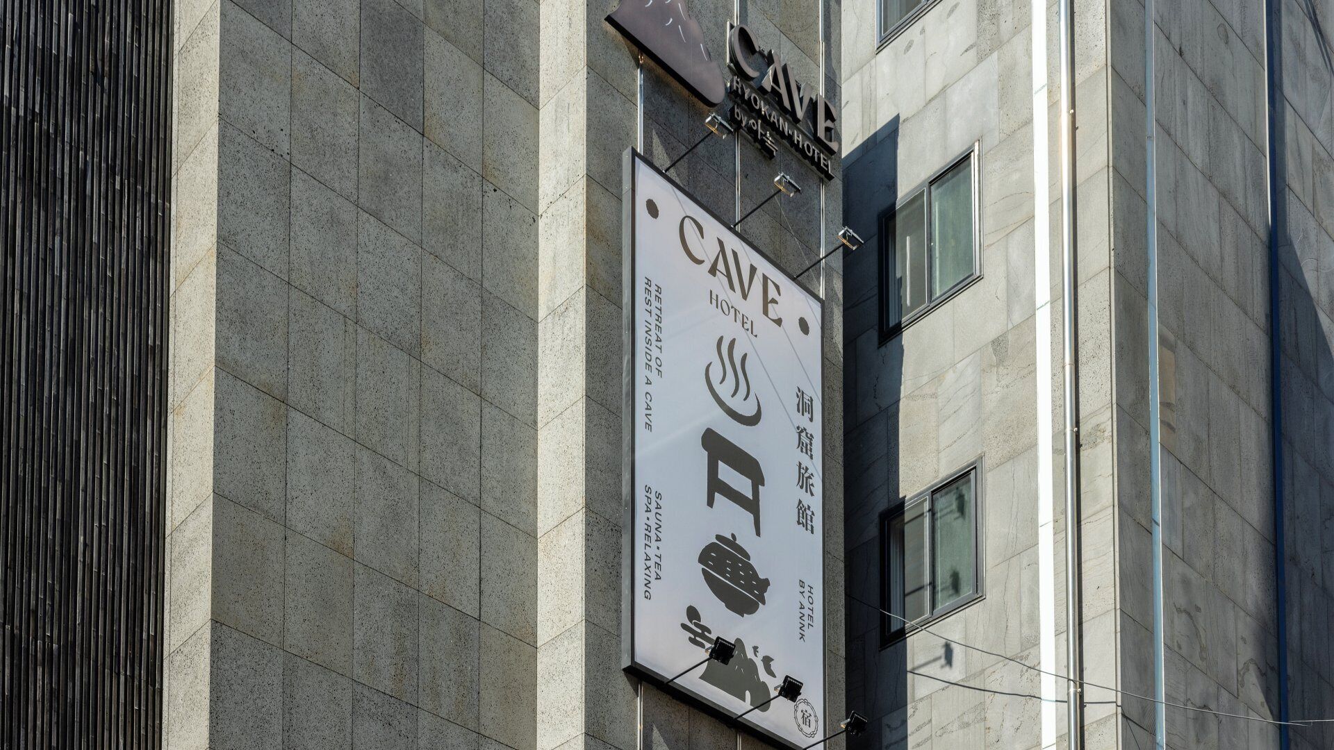 A building with a sign for 'CAVE HOTEL' and 'SAUNTE TEA' on the facade.