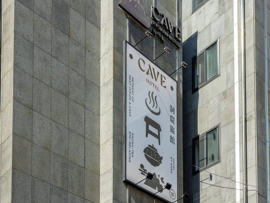 A building with a sign for 'CAVE HOTEL' and 'SAUNTE TEA' on the facade.