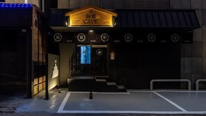 A hotel entrance with a sign reading 'Ryokan Cave Hotel' and multiple smaller signs indicating different rooms or areas. - Cave Ryokan Hotel by Anook Incheon Bupyeong Station (Incheon)