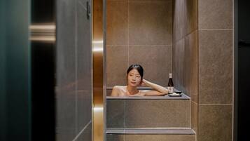Una persona en un ambiente tipo spa con una botella de líquido sobre la encimera.