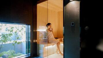 A modern interior with wooden paneling, a glass partition, and a view of greenery outside.