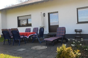 An outdoor patio with a table and chairs, a small table, and a bench. - in the Eifelwiese house (Monschau-Höfen)