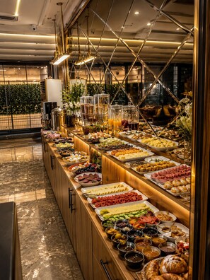 Un buffet proposant une variété de plats et de boissons, un comptoir en bois et une structure décorative au plafond.