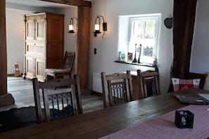A dining area with wooden furniture, a window with a view, and wall-mounted lights. - Holiday home in Buch with swimming pool (Buch)