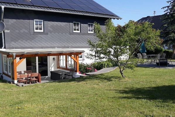 A house with a covered patio, a lawn, and a tree. - Holiday home in Buch with swimming pool (Buch)