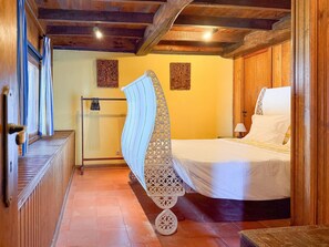 Ein Zimmer mit einem Bett, Holzwänden, einem Heizkörper und einem kleinen Tisch mit einer Lampe.