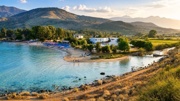 A coastal area with a beach, a small pier, and a building with a white facade. - Oceana Suites & Villas - Private Pool Hideaway (Exopoli)