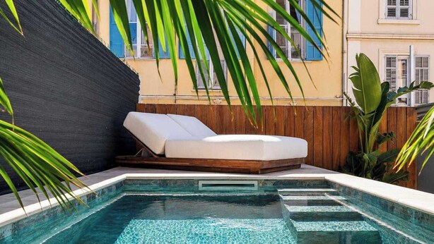Ein Pool mit Liegestuhl und Holzterrasse.