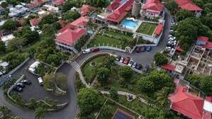 Zona residencial con piscina, rotonda y varios automóviles estacionados.