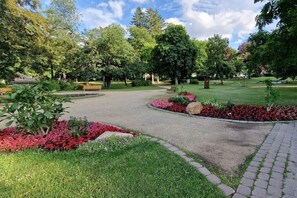 Ein Park mit Wegen, Bänken und Blumenbeeten.