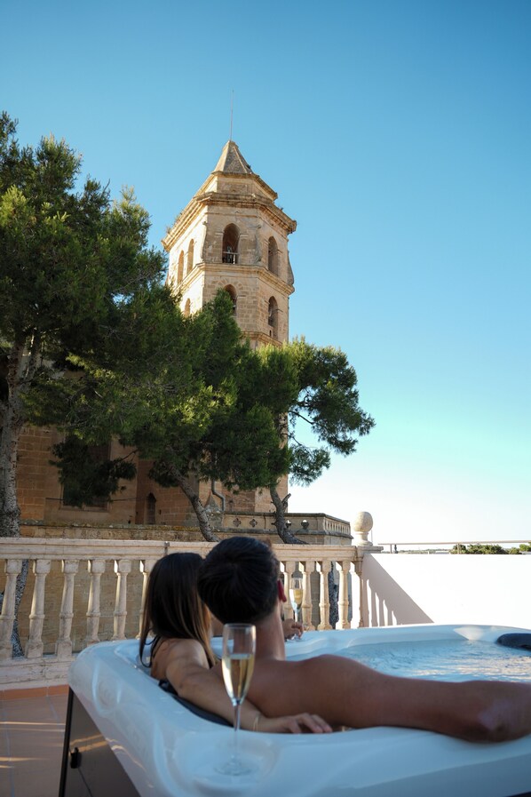 A hot tub with a view of a tower and trees.
