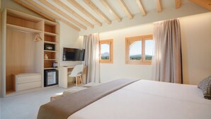 Une chambre à coucher avec un lit, un bureau, une télévision et une armoire.
