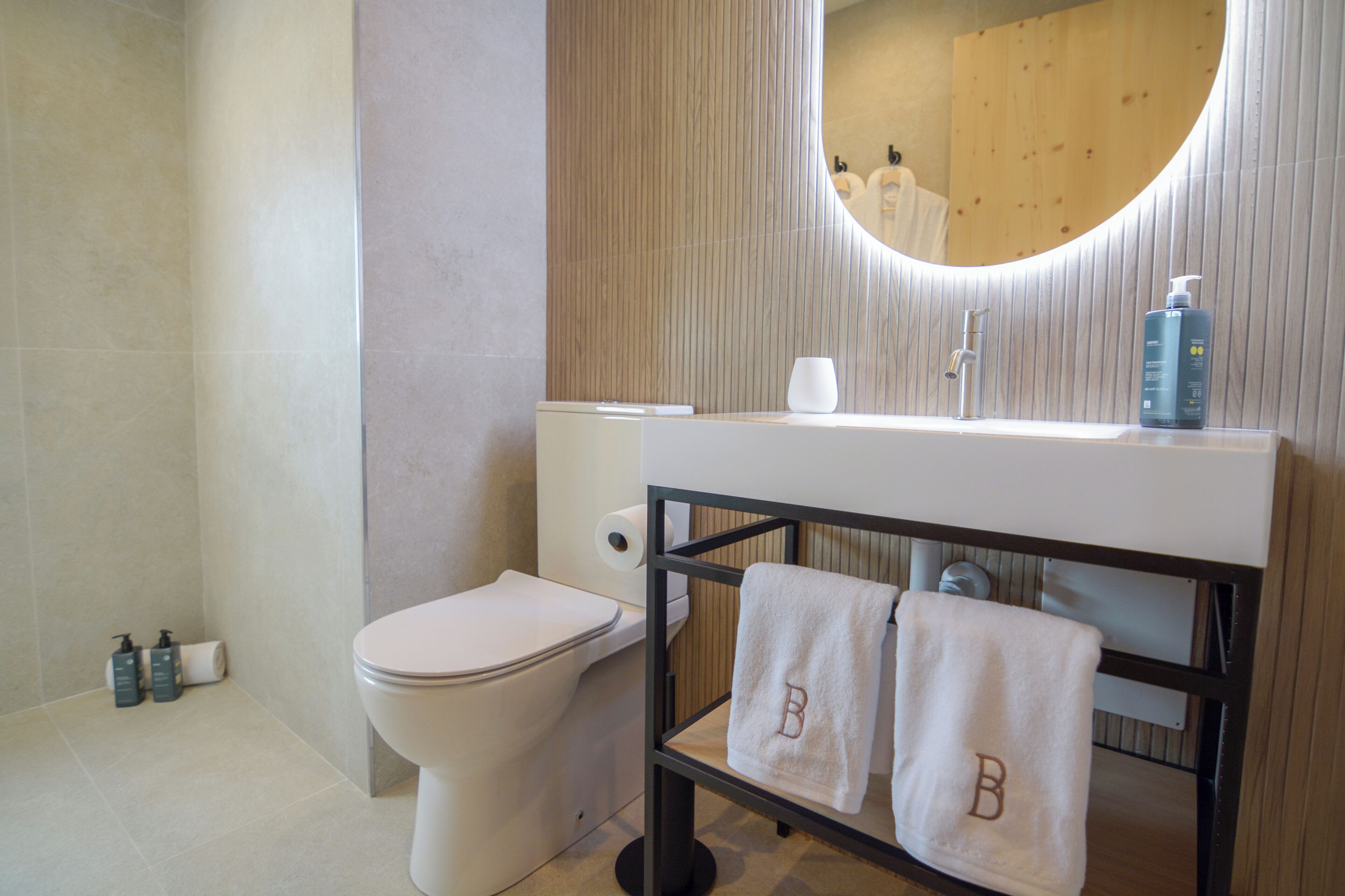 Un baño moderno con inodoro, lavamanos y espejo.