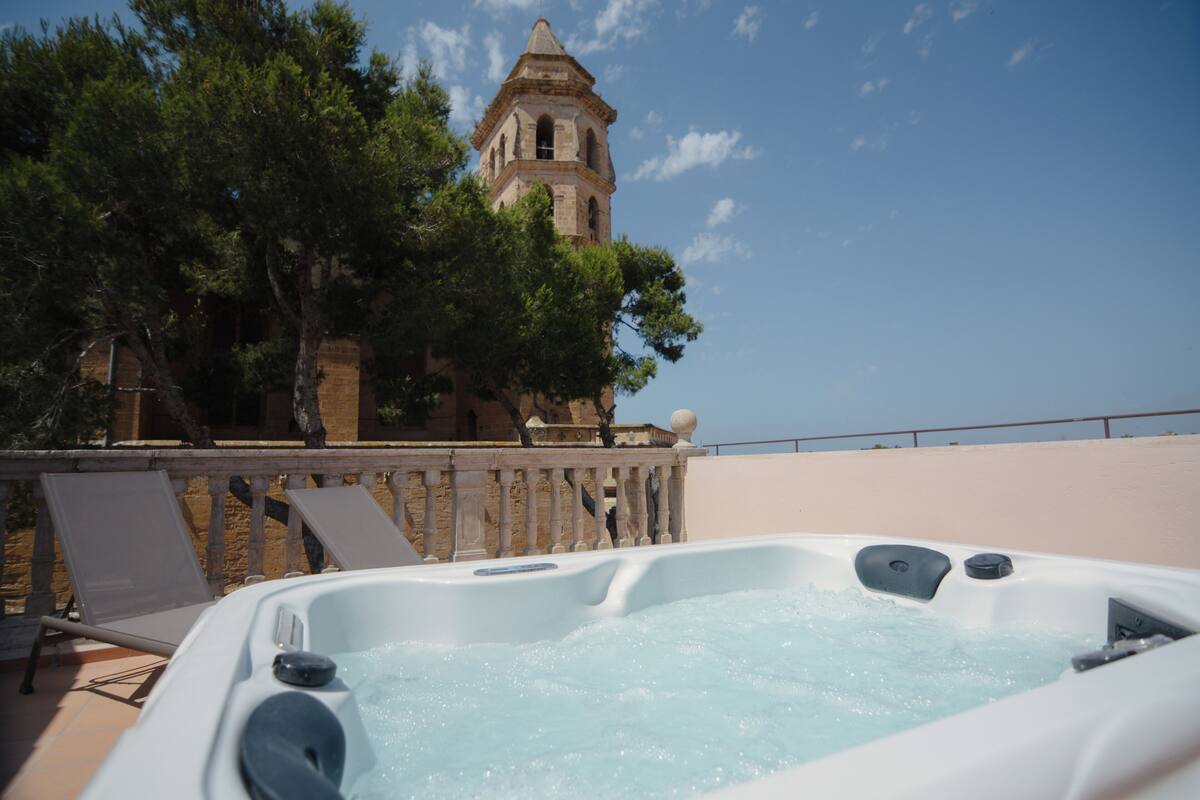 A hot tub with a stone tower in the background.