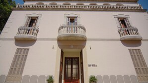 Un bâtiment doté d’une entrée centrale, de deux balcons et d’une enseigne indiquant « BYTRA ».