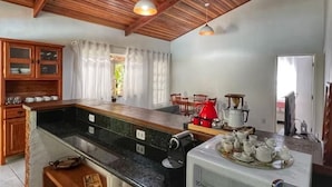 Cozinha com vigas de madeira no teto, micro-ondas e cafeteira.