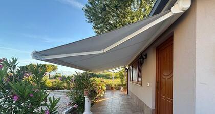 A guesthouse with a fireplace in the garden of a villa with a pool; the beach is 5 minutes away