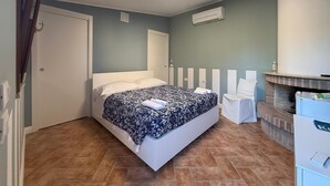 Un dormitorio con cama, chimenea, puerta y equipo de aire acondicionado.