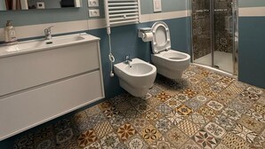 Un baño con lavamanos, bidé y ducha.